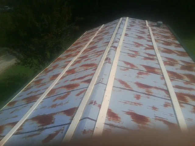 Rusted metal roof panels with new wood purlins before replacement — Storm Damage Roof Repair in New Windsor by Roofing Brothers
